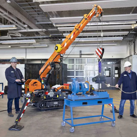 Two technicians working with mini crane in the a lab
