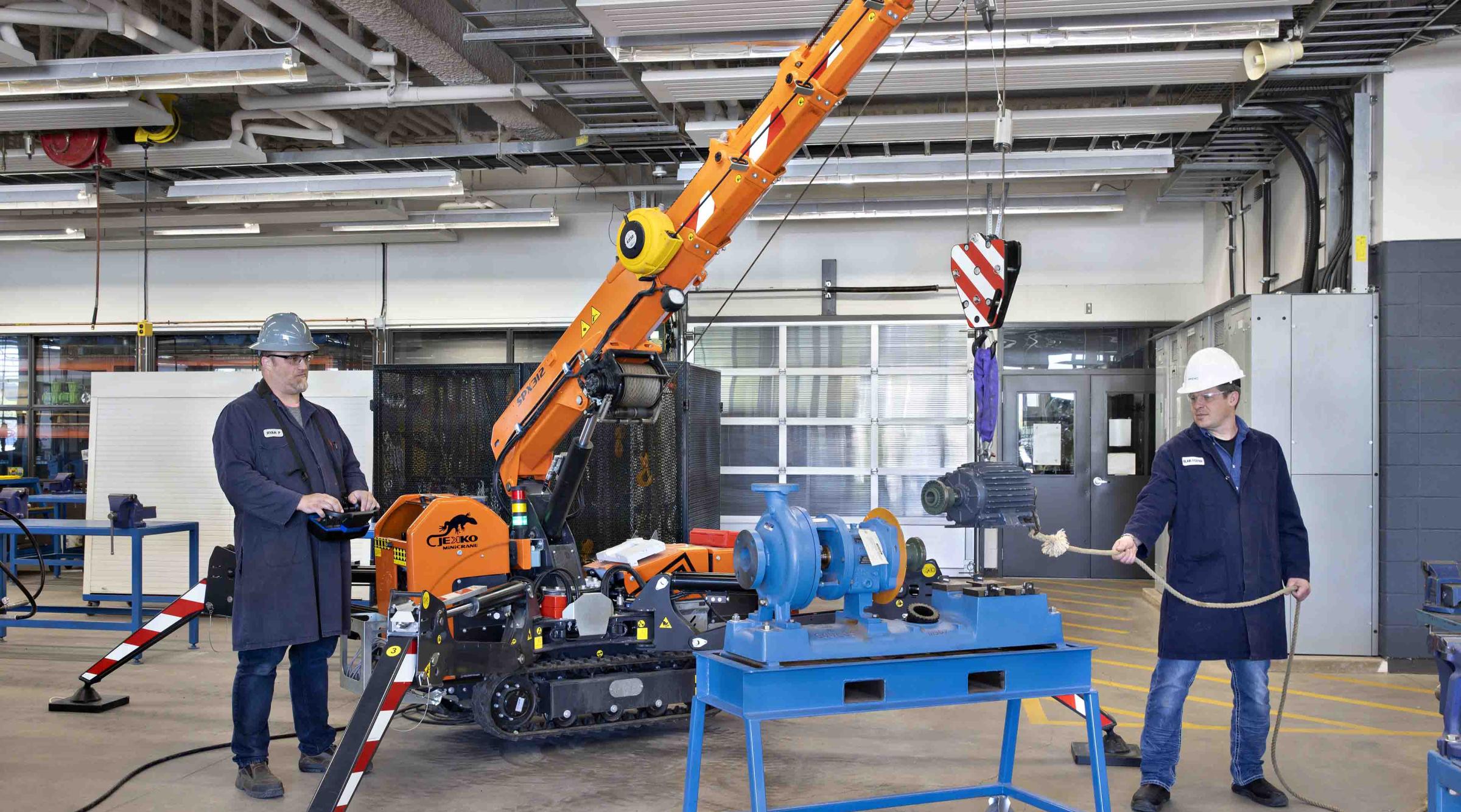 Two technicians working with mini crane in the a lab