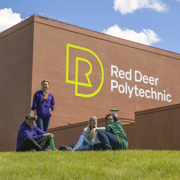 Students sit on lawn outside RDP's Arts Centre